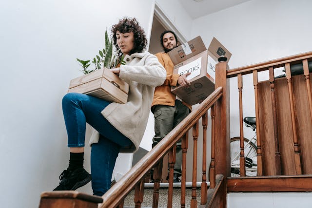people going down stairs with moving boxes
